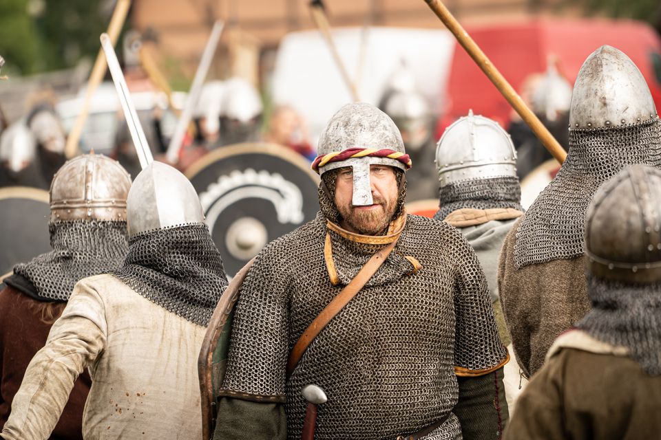 Junger Freiwilliger spielt einen Wikingerhäuptling bei einem traditionellen Freilichtspiel.