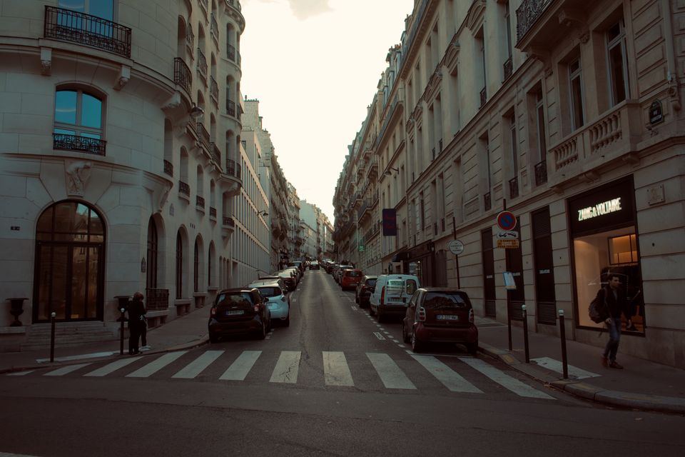 Polizeiabsperrung mit flatterndem Band vor einer belebten Straße in Paris bei Nacht.