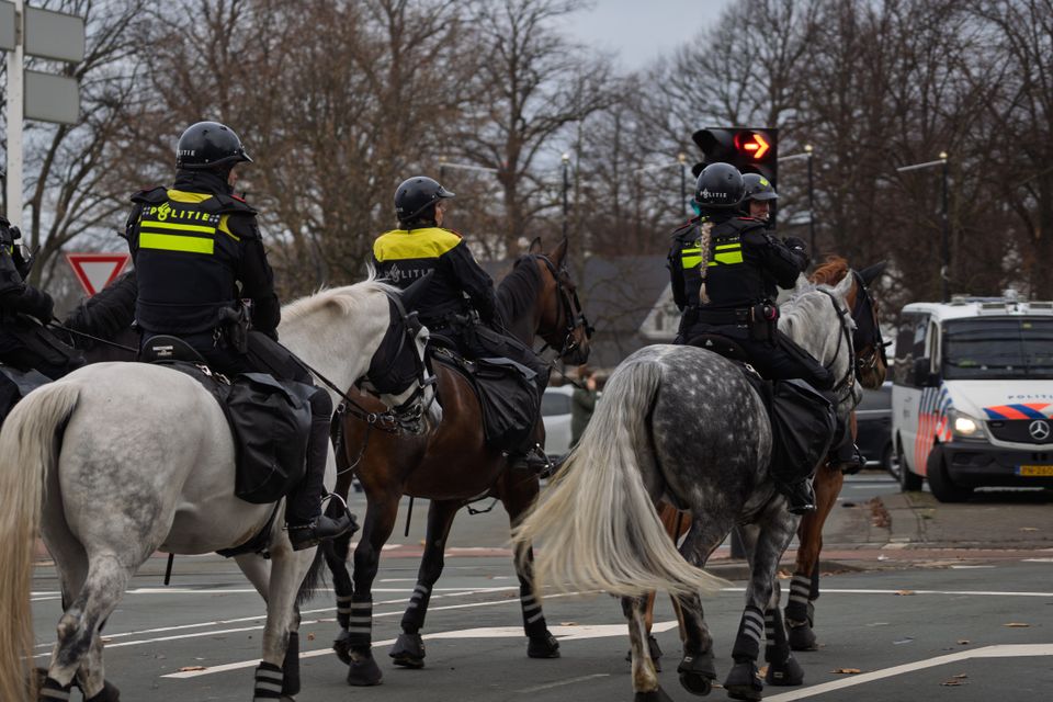 Polizeibeamte sichern einen Tatort mit gelbem Absperrband nach einem gemeldeten Verbrechen.